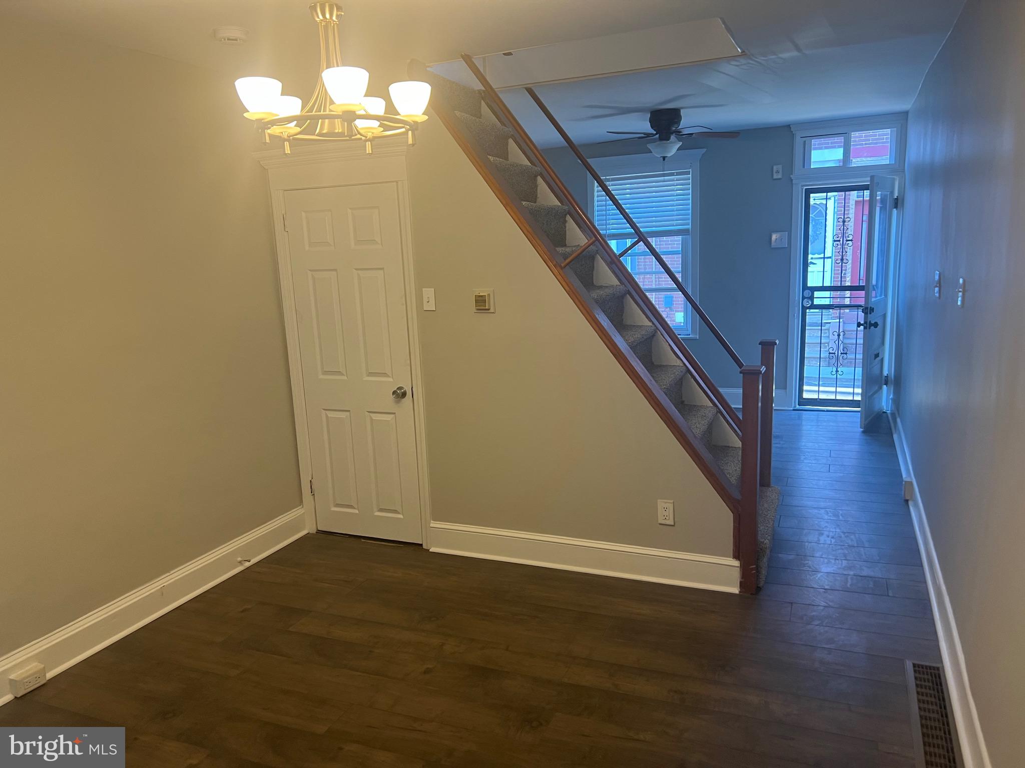 a view of a hallway with wooden floor and staircase