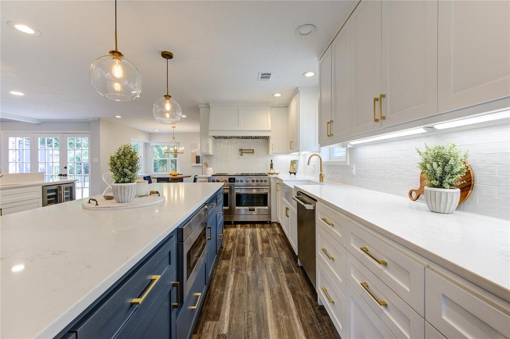 a large kitchen with kitchen island white cabinets and wooden floor