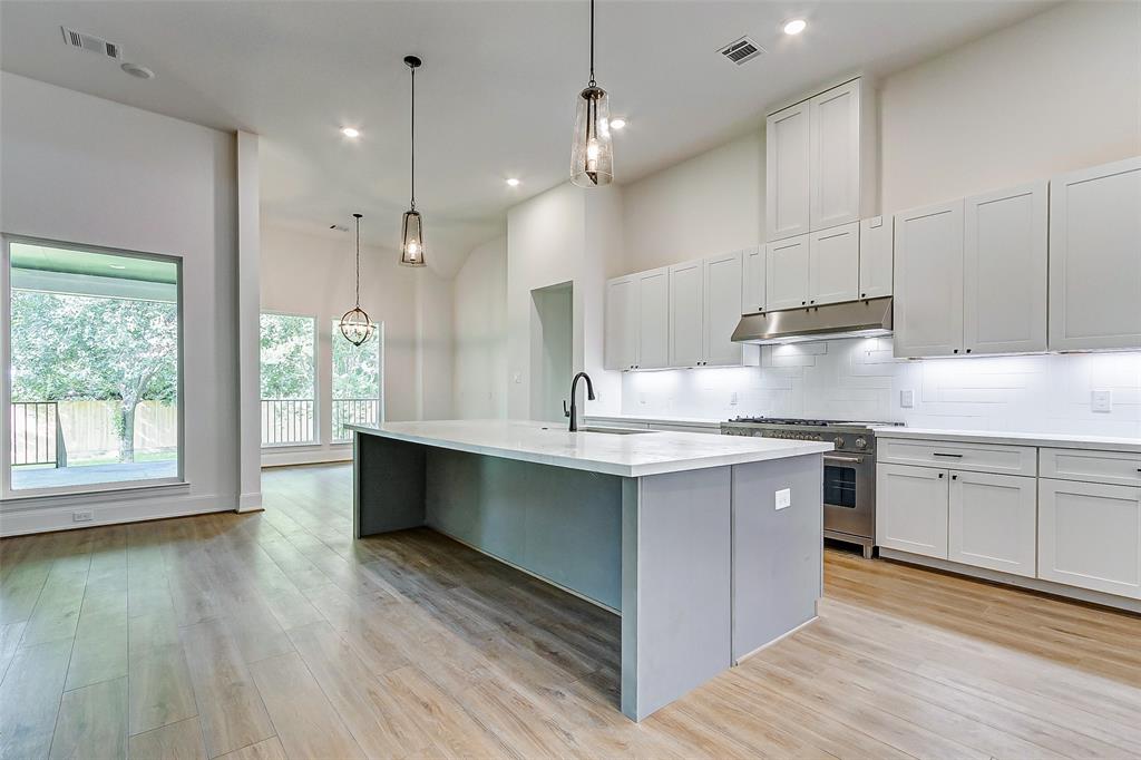 a large kitchen with kitchen island a sink stainless steel appliances and cabinets