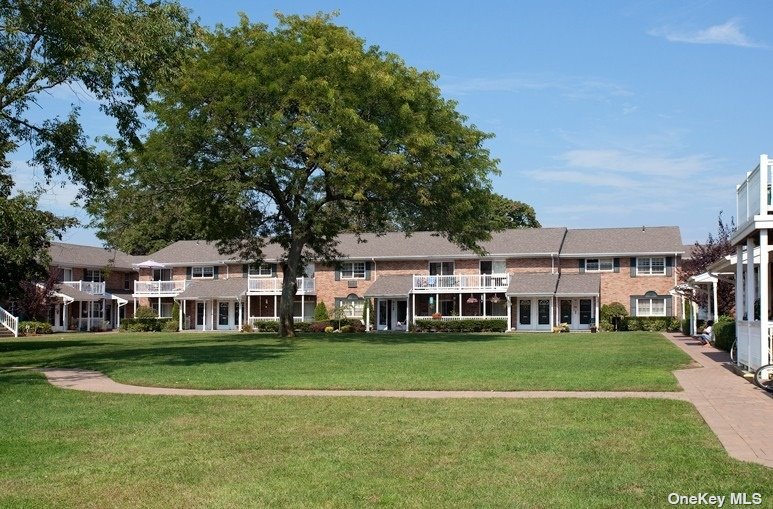 a view of a white house with a big yard and trees