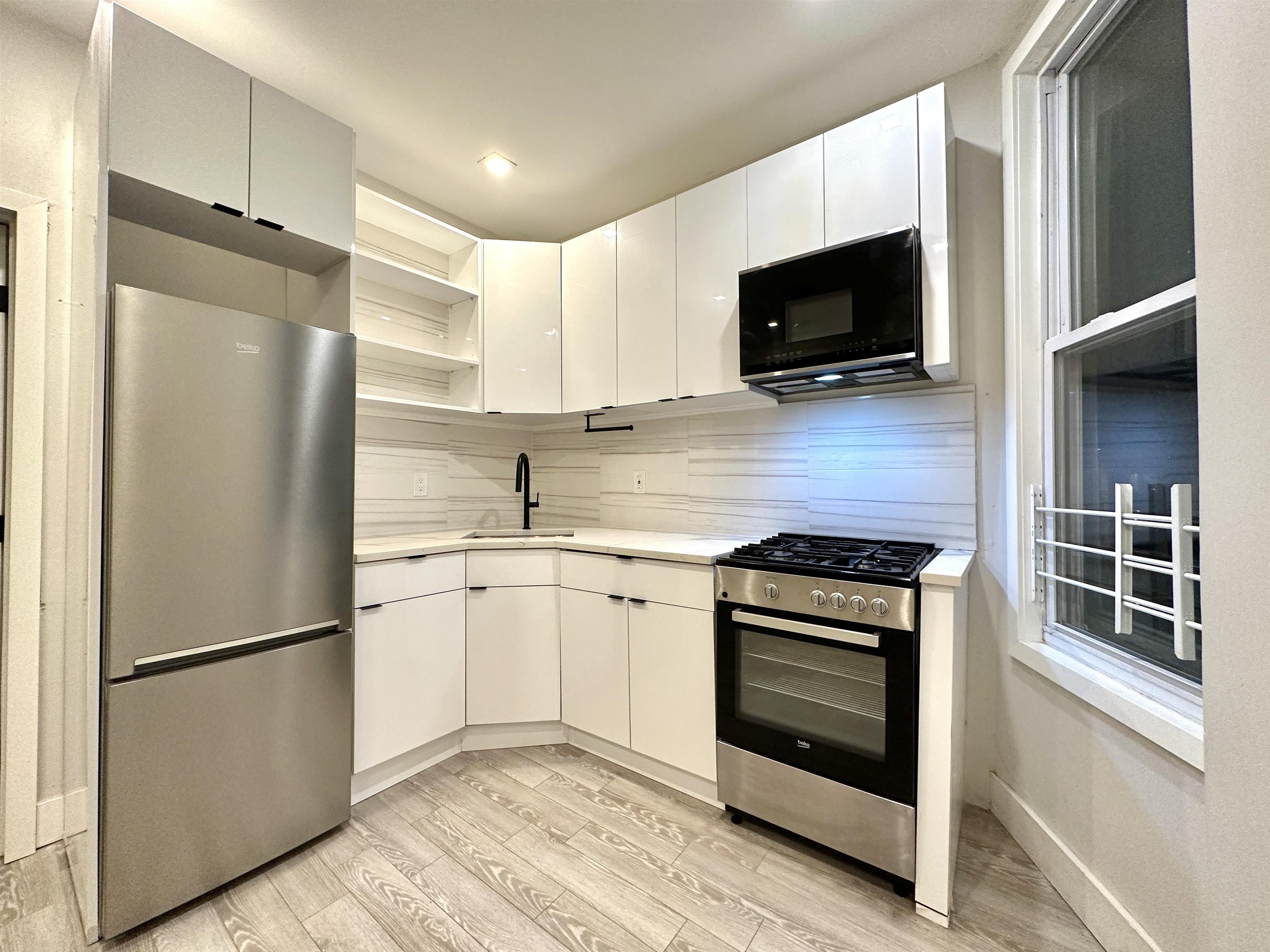 a kitchen with stainless steel appliances a refrigerator stove and microwave