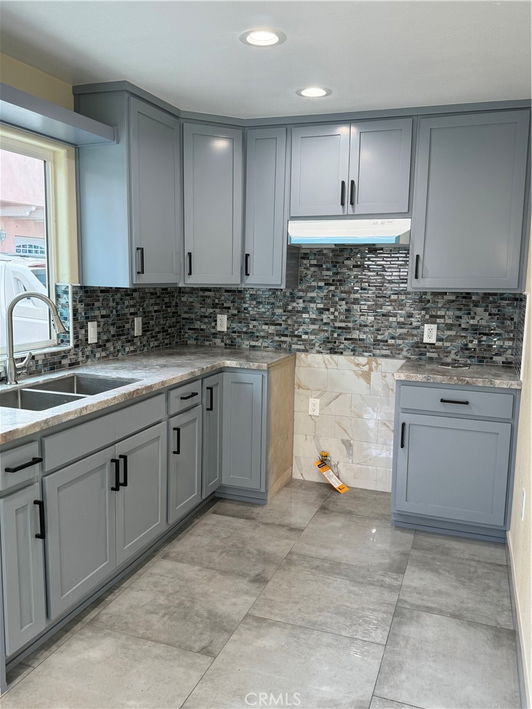 a kitchen with a sink stove and cabinets