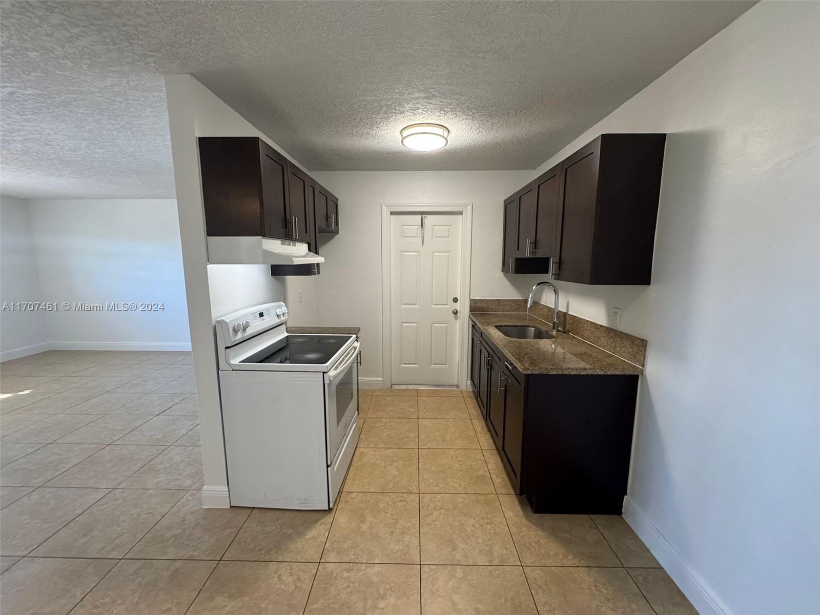 a kitchen with a sink a stove and cabinets