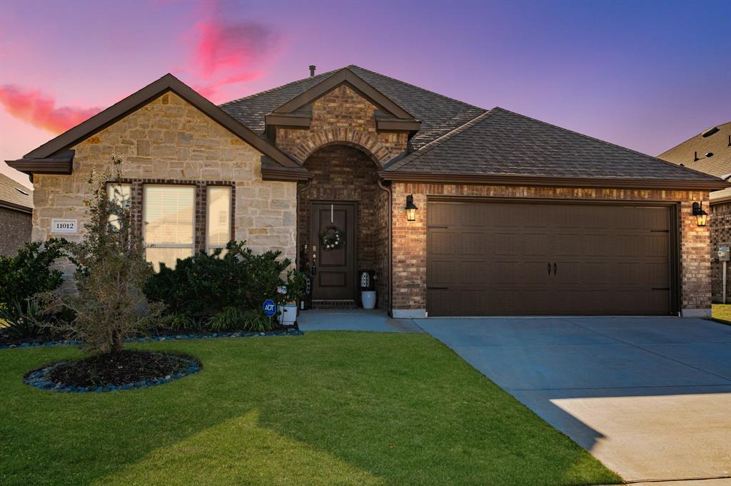 View of front facade with a yard and a garage