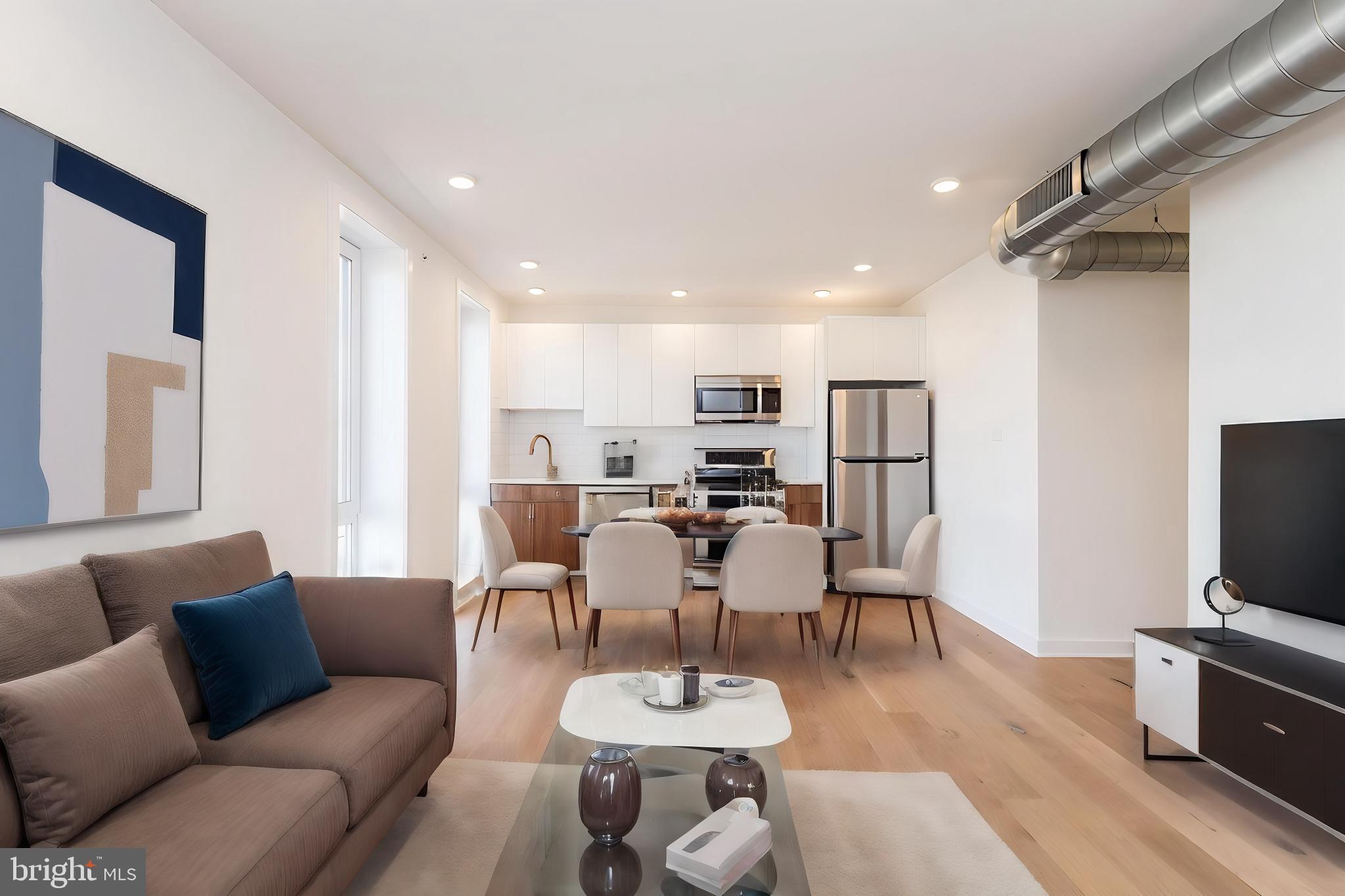 a living room with furniture a flat screen tv and a table