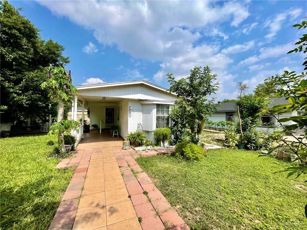 View of front of property with a front lawn and a carport