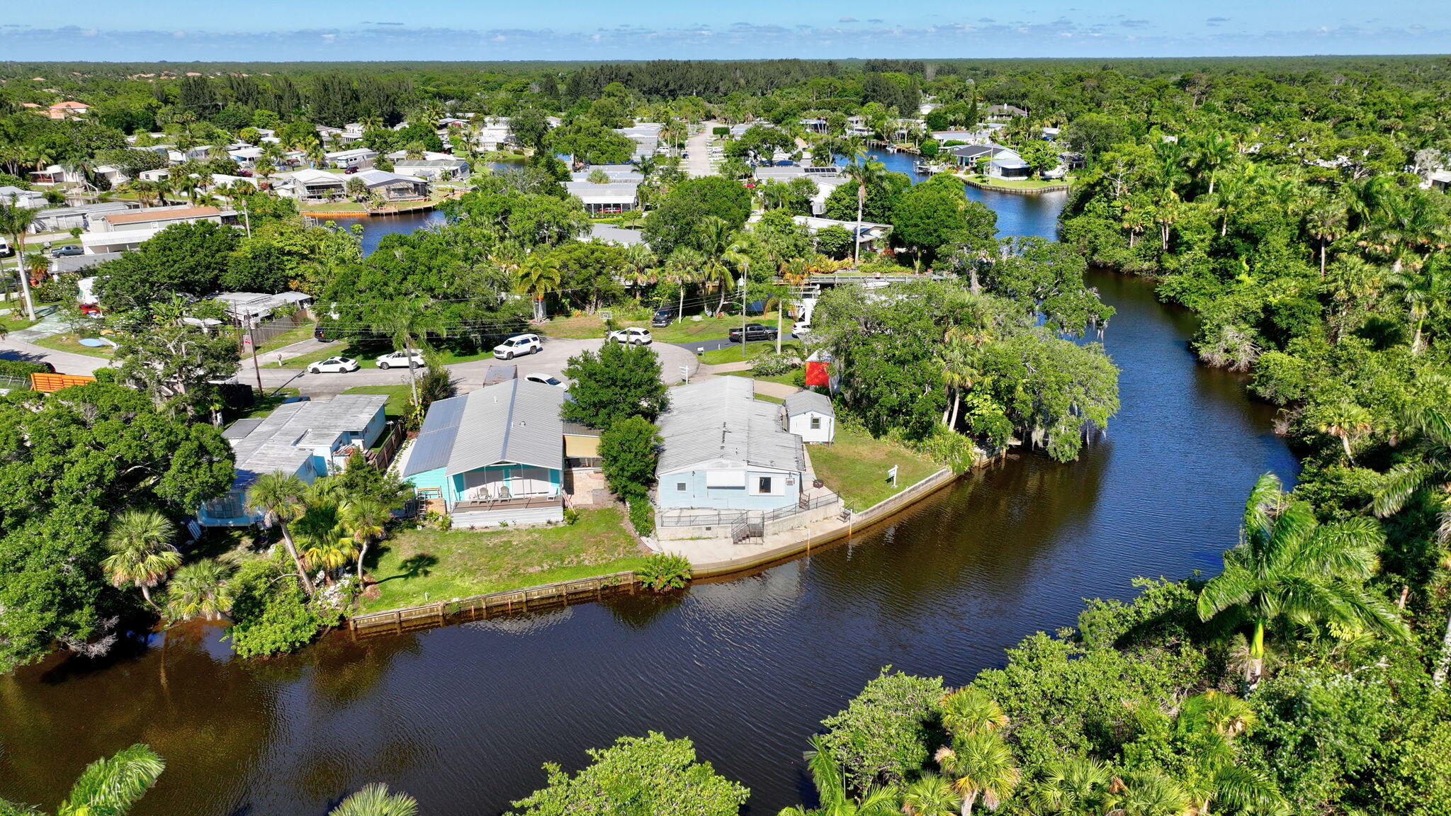 an aerial view of residential houses with outdoor space and lake view