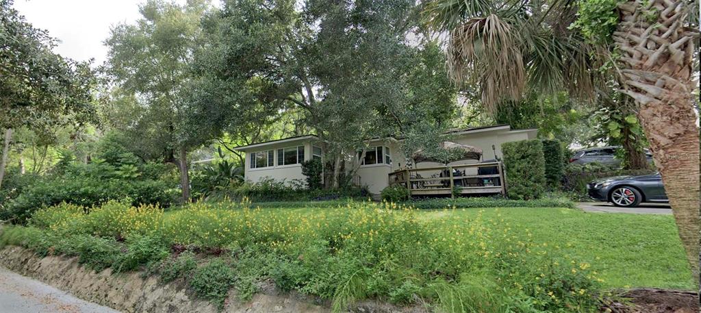 a view of a house with a yard and sitting area