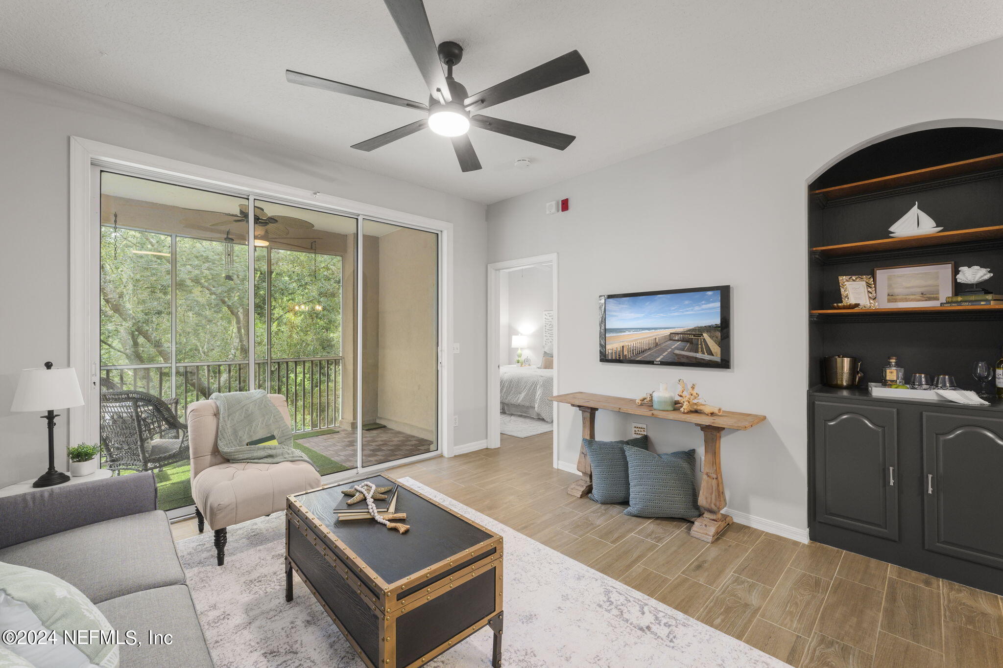 a living room with furniture a window and a flat screen tv