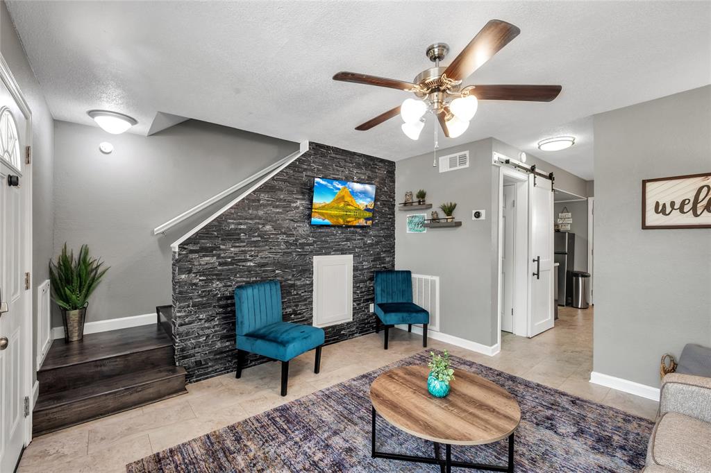 a living room with furniture a fireplace and a chandelier