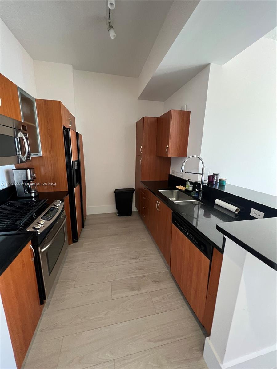 a kitchen with stainless steel appliances a sink stove and refrigerator