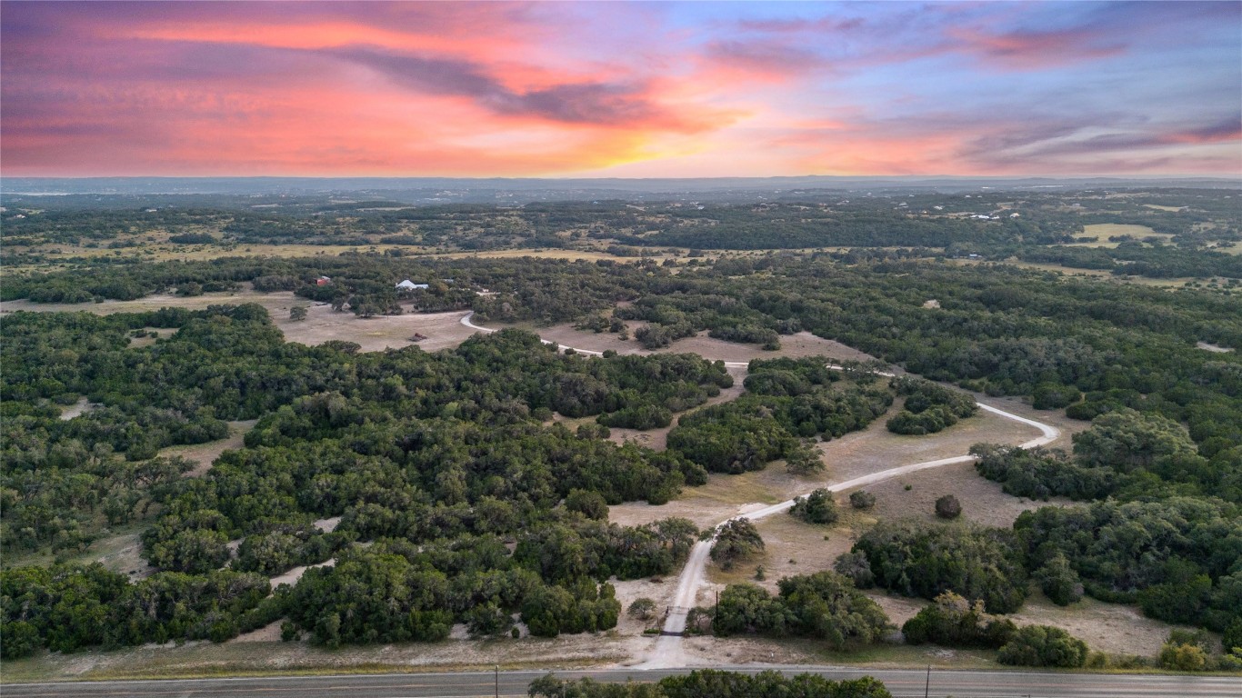 an aerial view of residential houses with outdoor space and trees