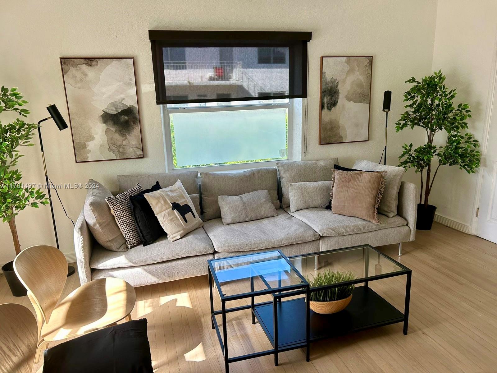 a living room with furniture and a painting on the wall