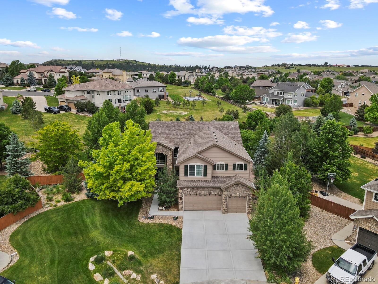 an aerial view of residential houses with outdoor space and trees