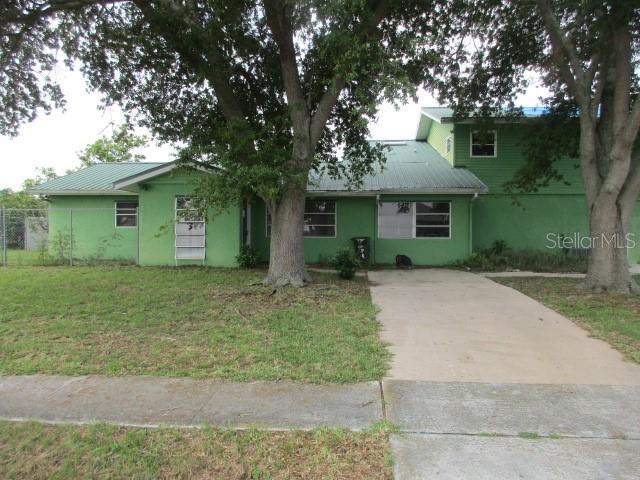 a front view of house with yard and trees