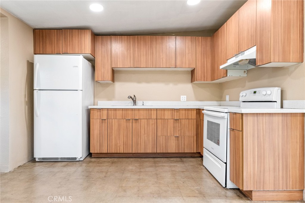 a kitchen with a refrigerator a sink and cabinets