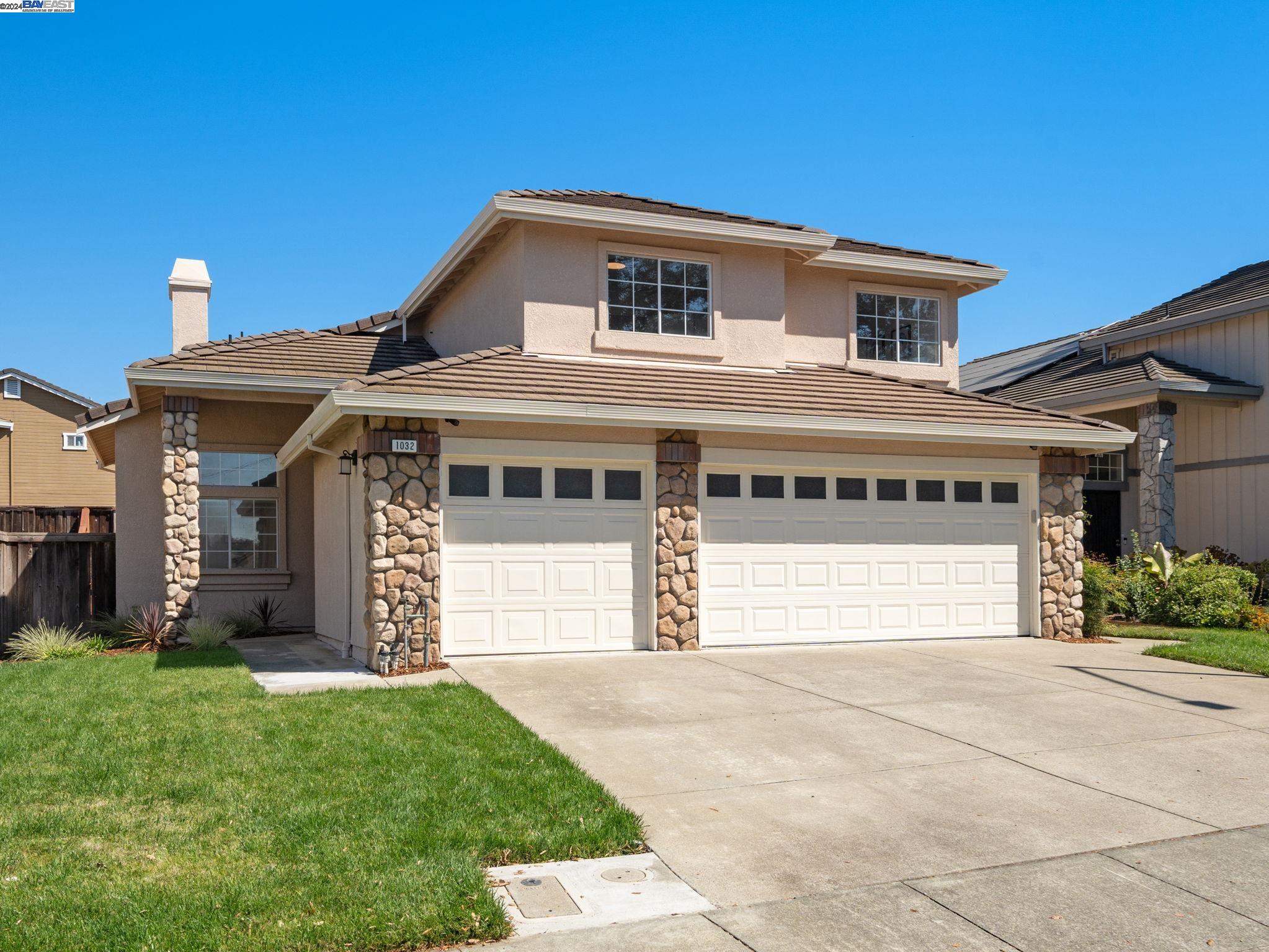 a front view of a house with a yard and garage