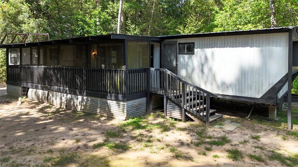 a view of house with wooden deck and backyard