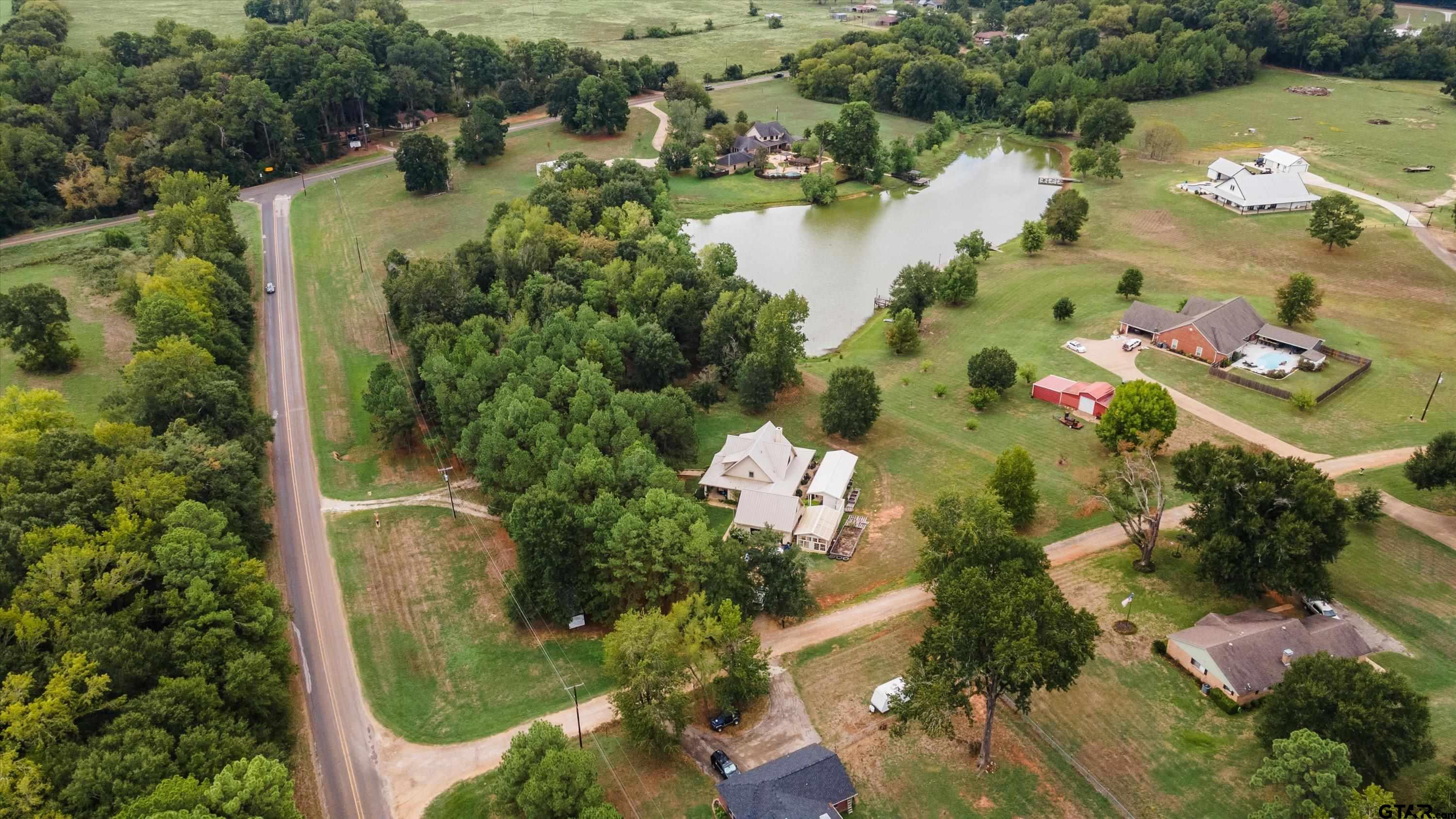 an aerial view of lake residential house with swimming pool and outdoor seating