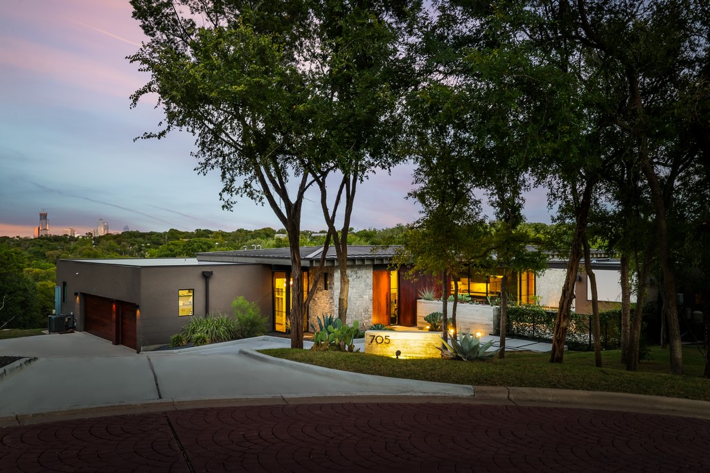 a view of a house with a big yard and large tree