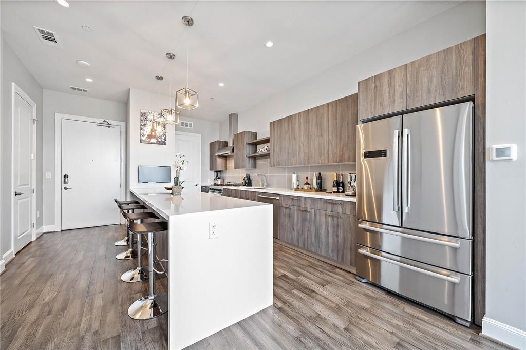 a kitchen with kitchen island a counter top space stainless steel appliances and cabinets