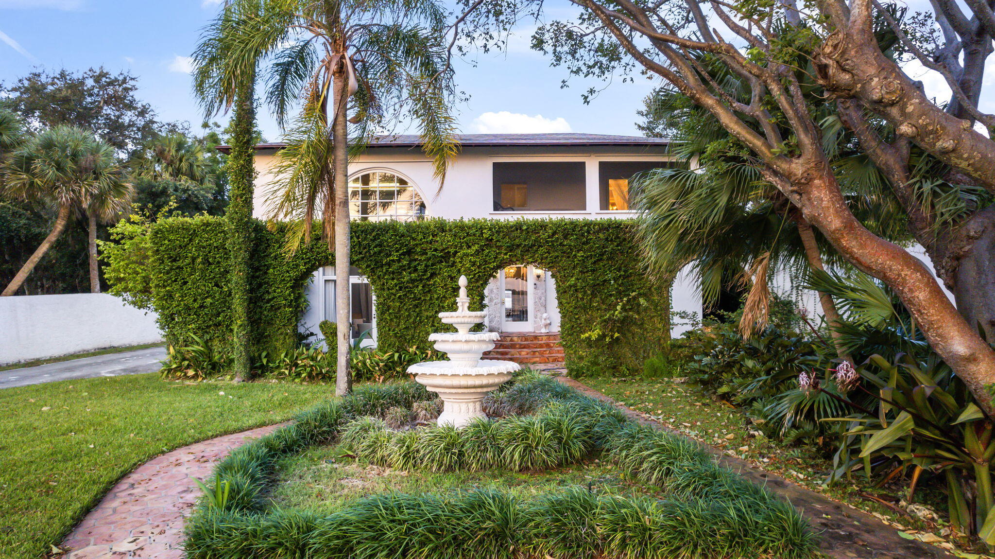 a view of a house with a yard and potted plants