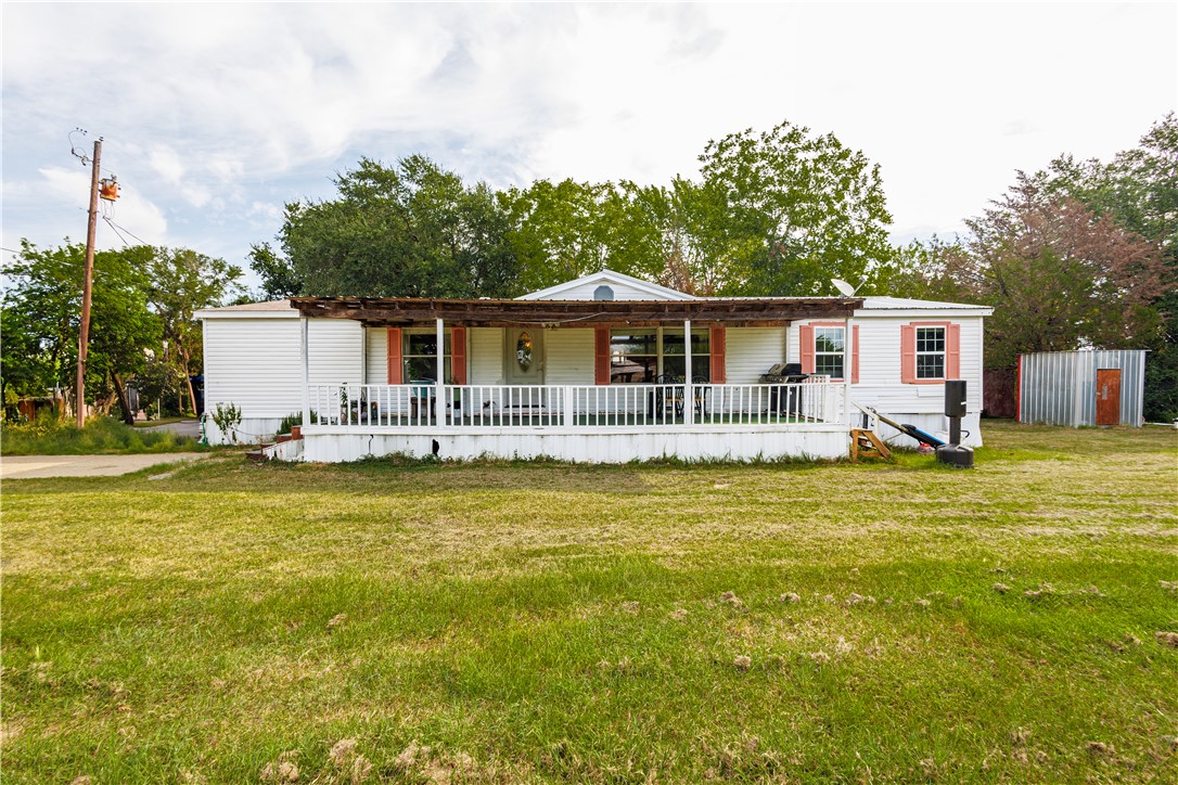 a front view of house with yard and swimming pool