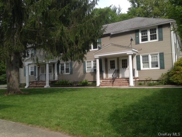 a view of a house with a yard deck and a large tree