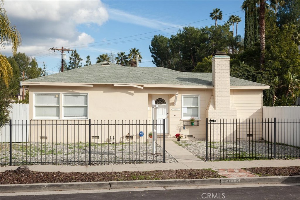 a view of a brick house with wooden fence