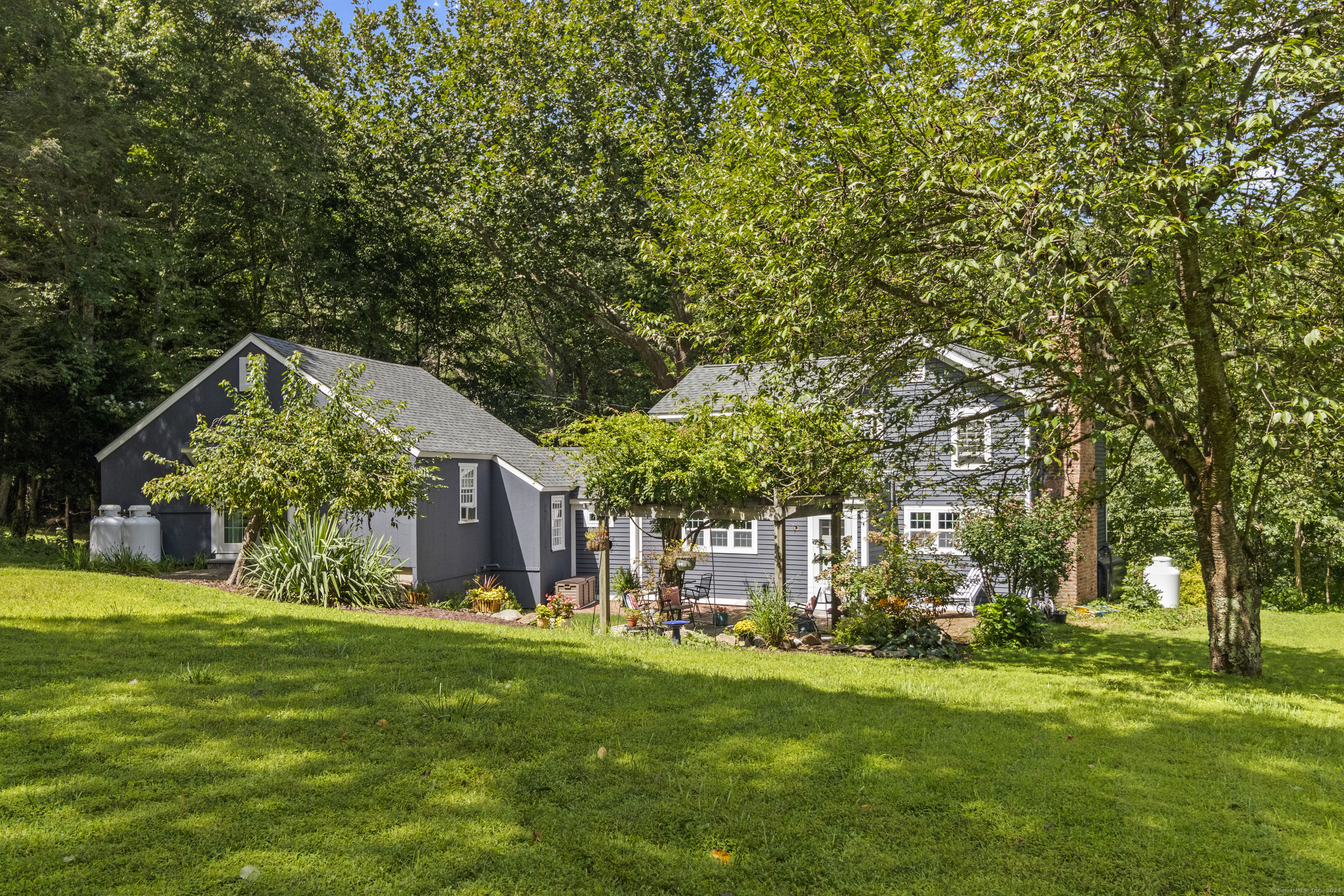 a view of a house with a big yard and large trees