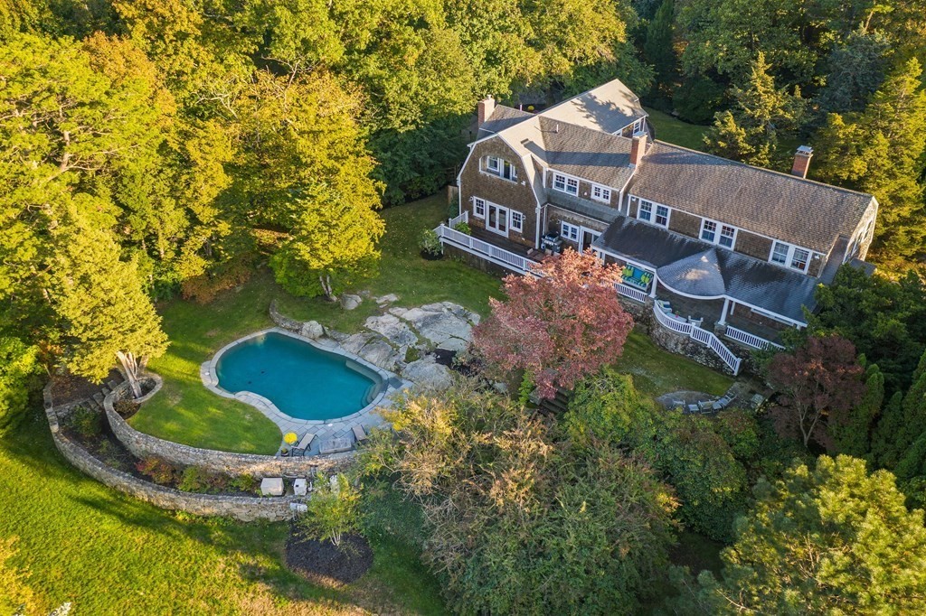 a view of a house with a yard and large trees