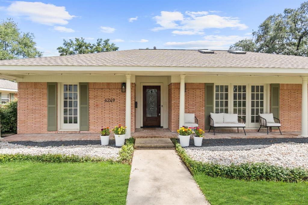 a front view of a house with a garden and plants