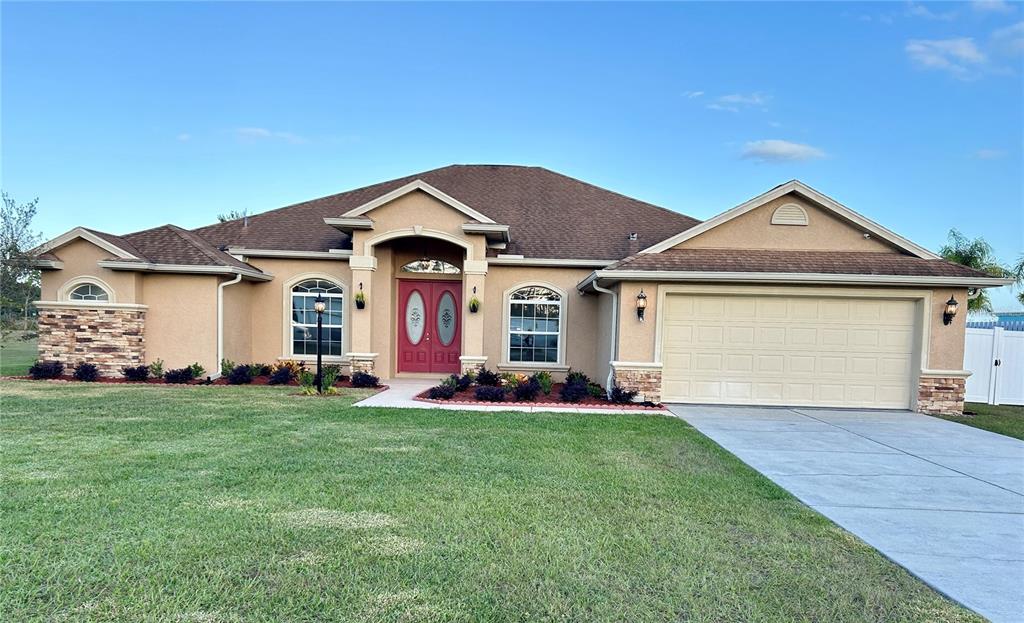 a front view of a house with a garden and yard