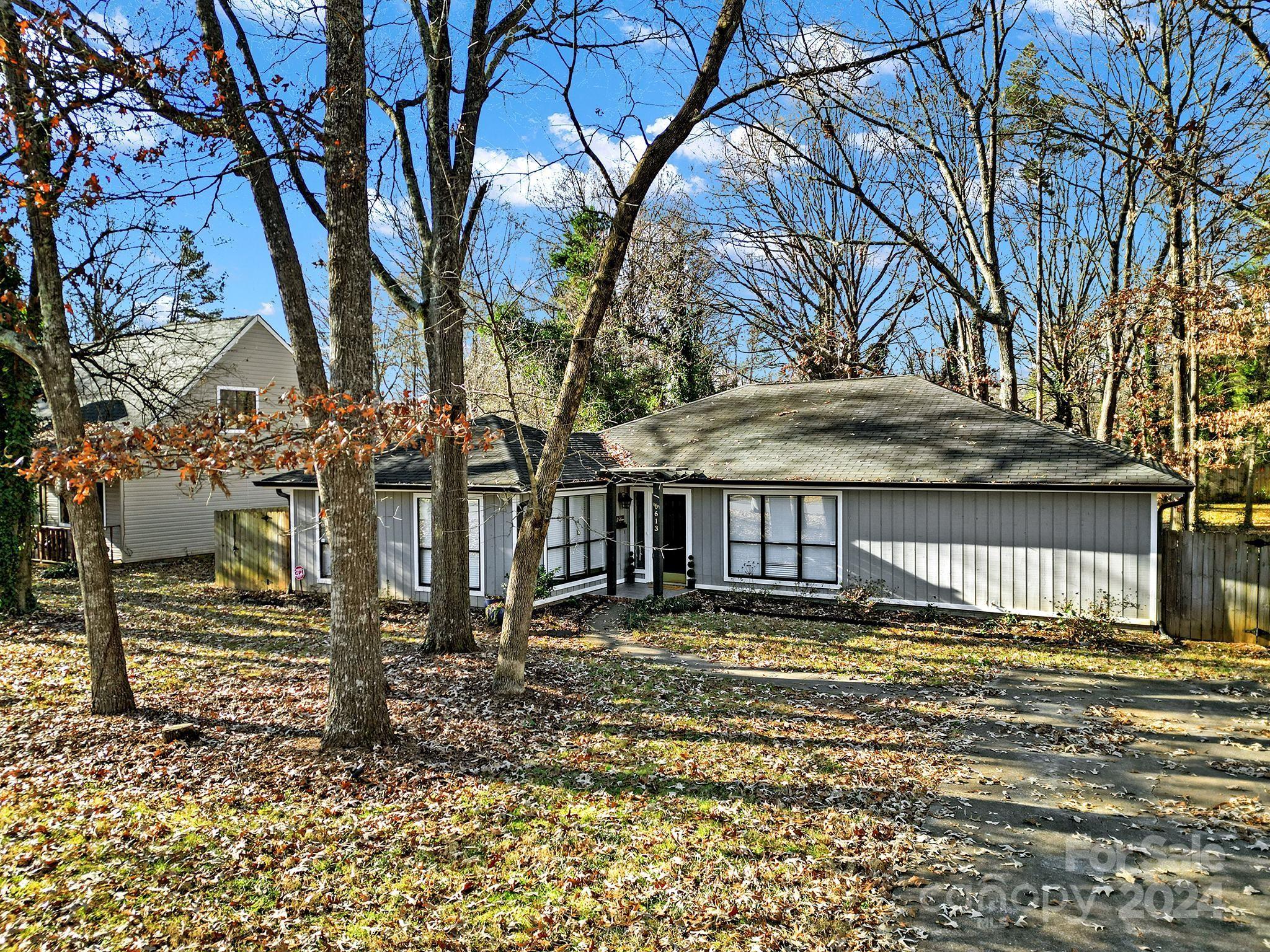 a view of a house with a large tree and a yard