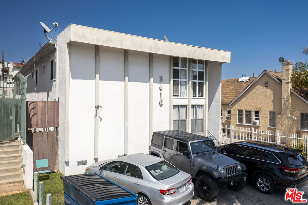 a couple of cars parked in front of a house