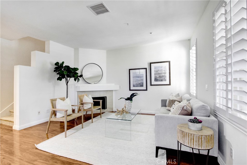 a living room with furniture a fireplace and a potted plant