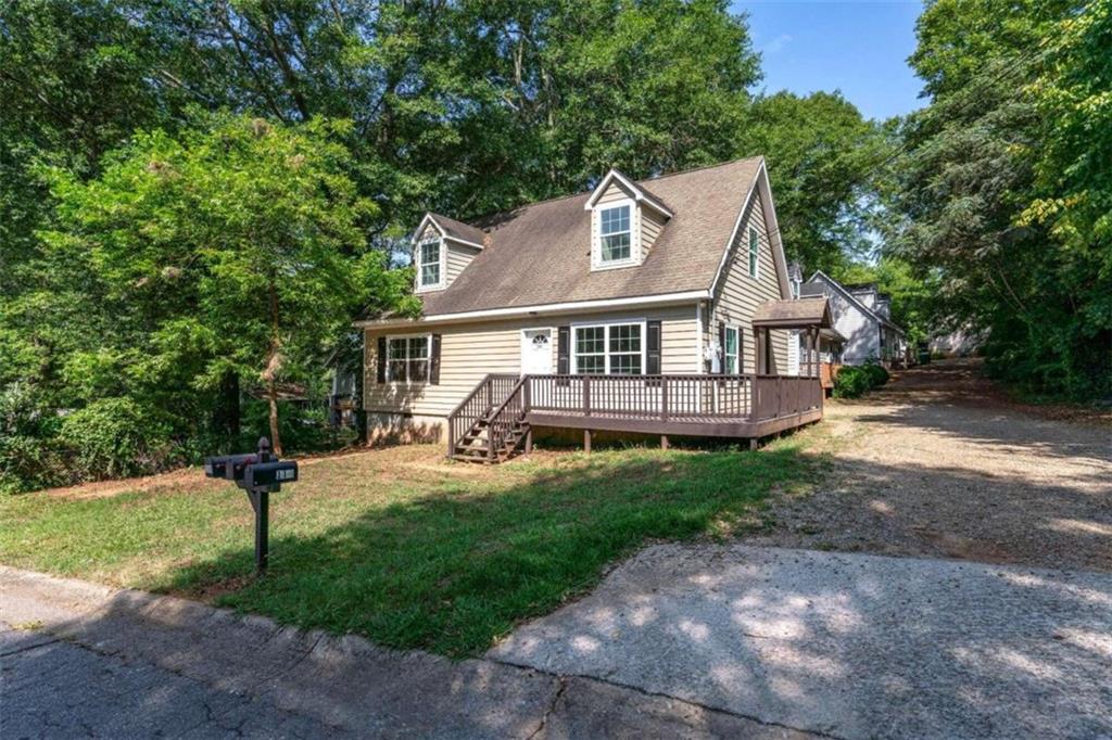 a view of a house with a yard and large tree