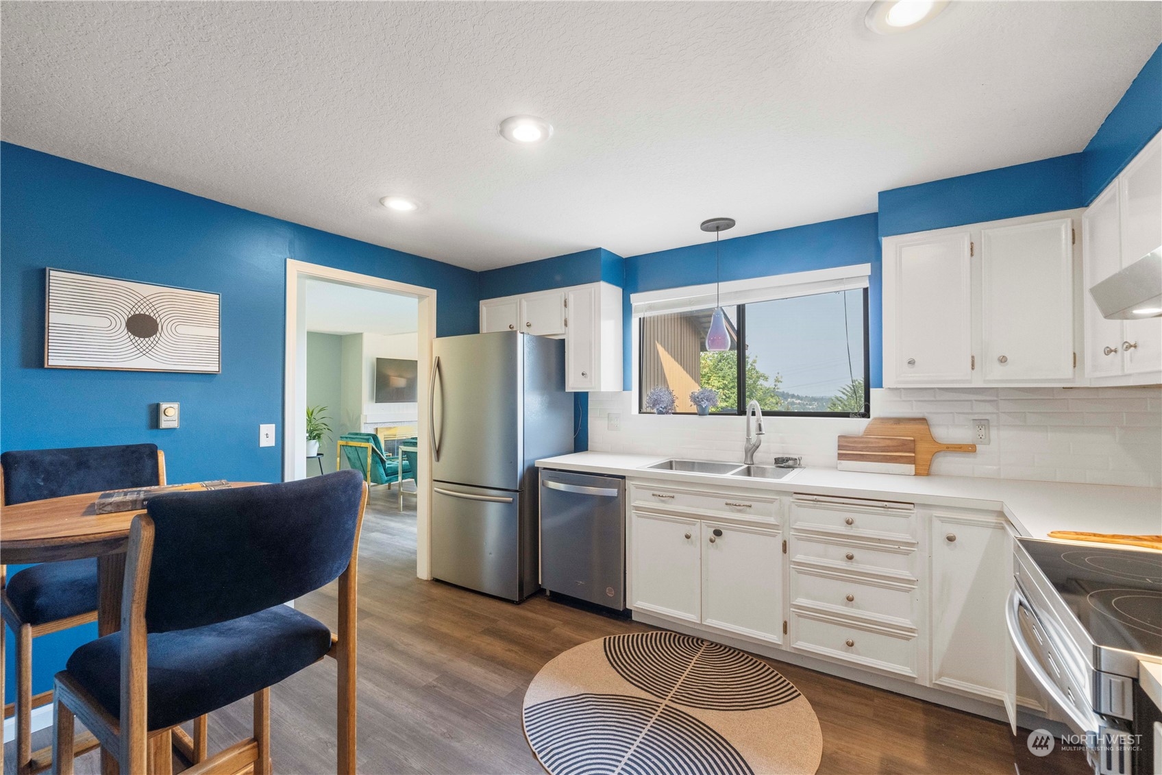 a kitchen with a refrigerator a sink dishwasher with a dining table and chairs