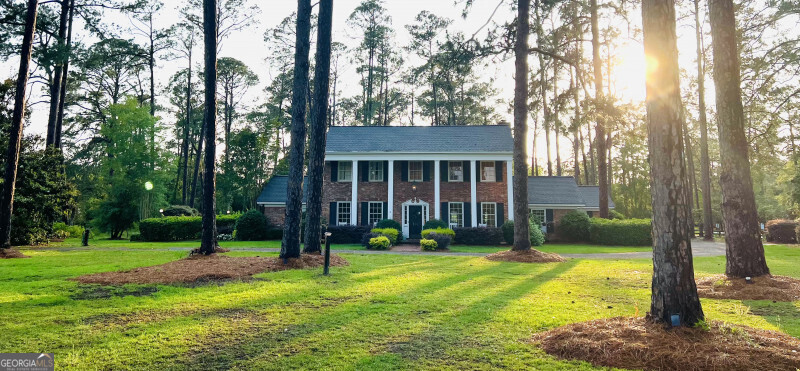 a view of a house with a yard deck and a tree