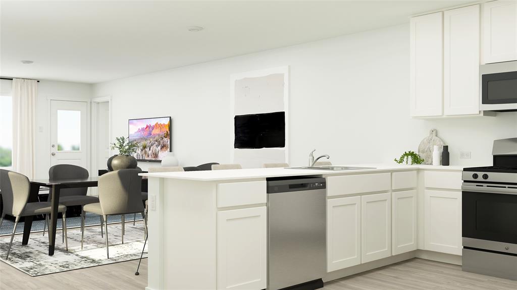 a kitchen with a sink cabinets and wooden floor