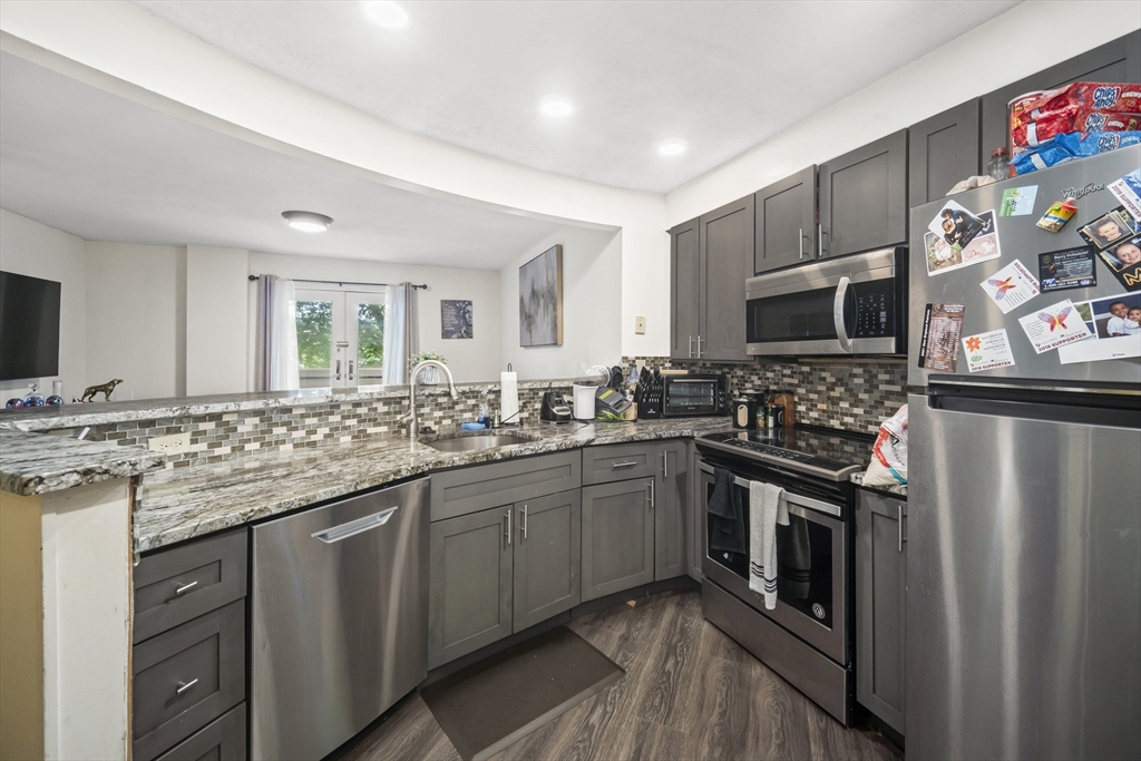 a kitchen with stainless steel appliances granite countertop a sink stove and refrigerator