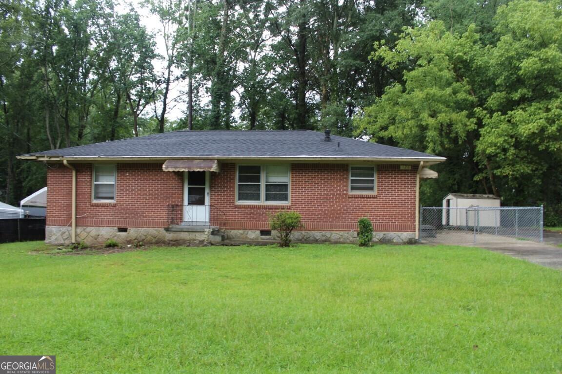 a view of a house with a yard and sitting area