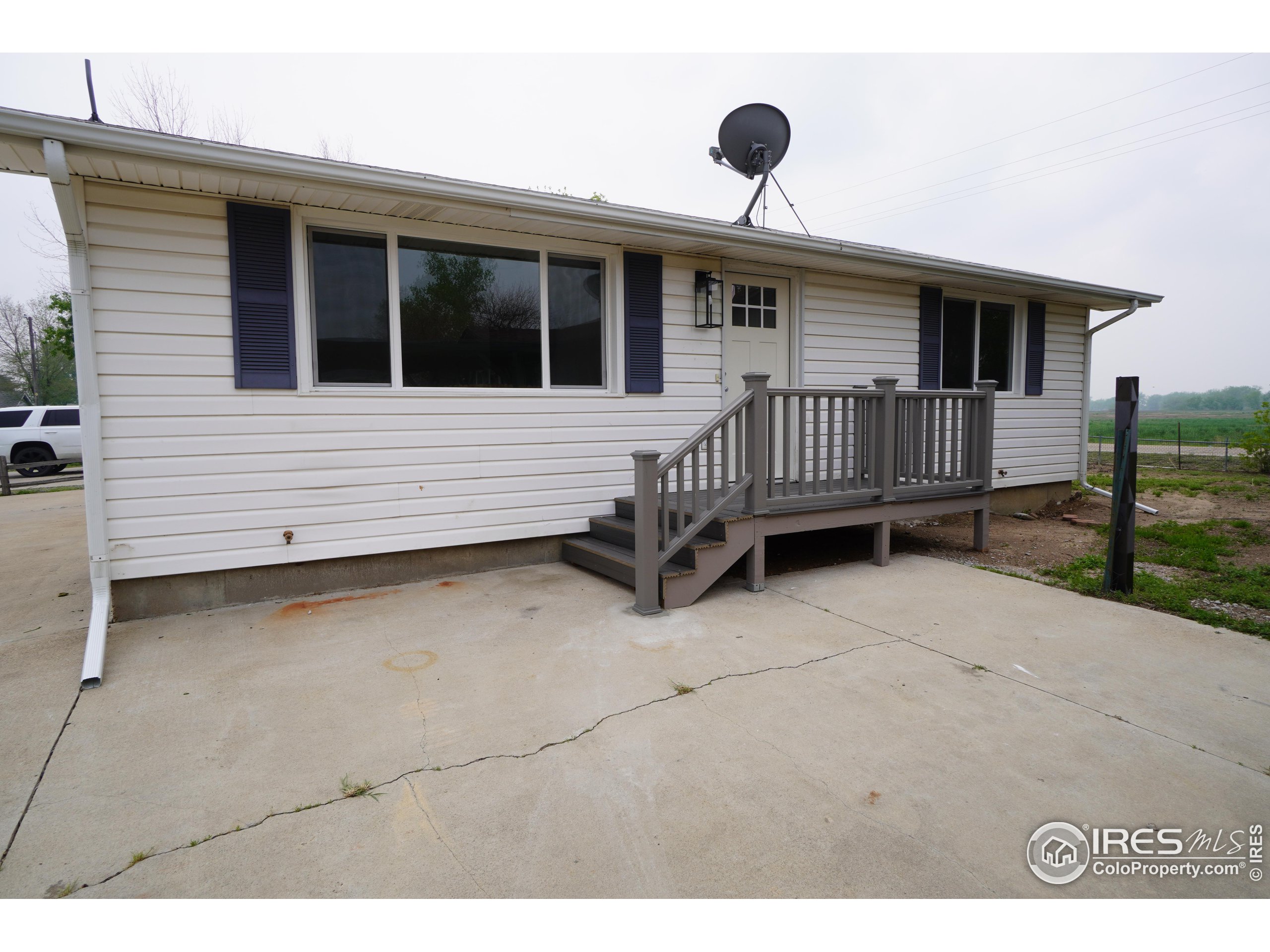 a view of a house with wooden deck and a yard