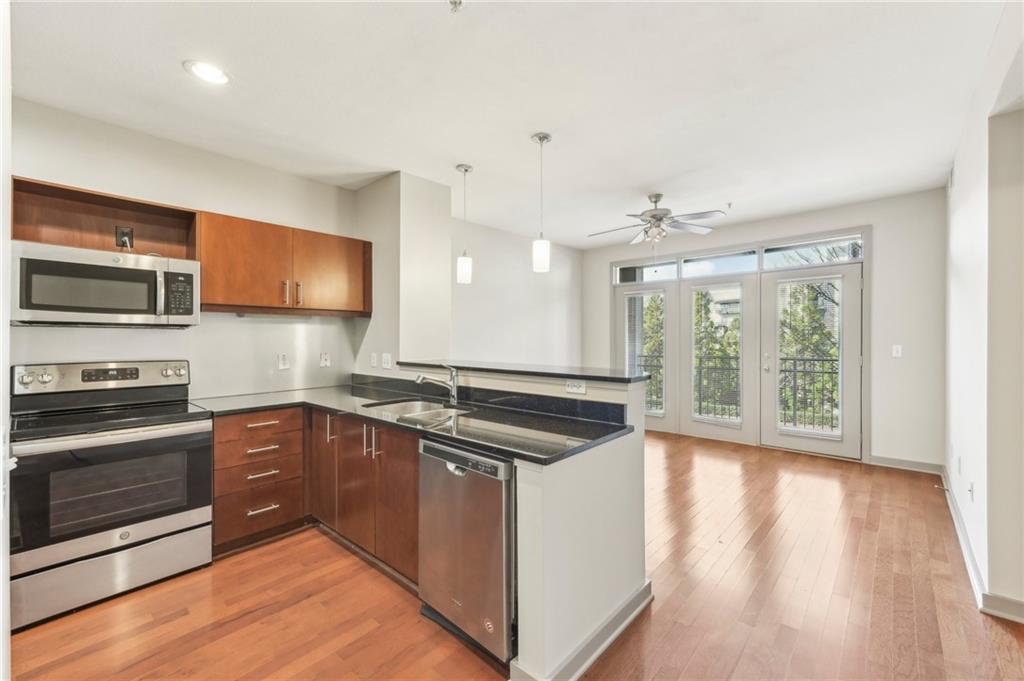 a kitchen with stainless steel appliances granite countertop a stove a sink and a microwave