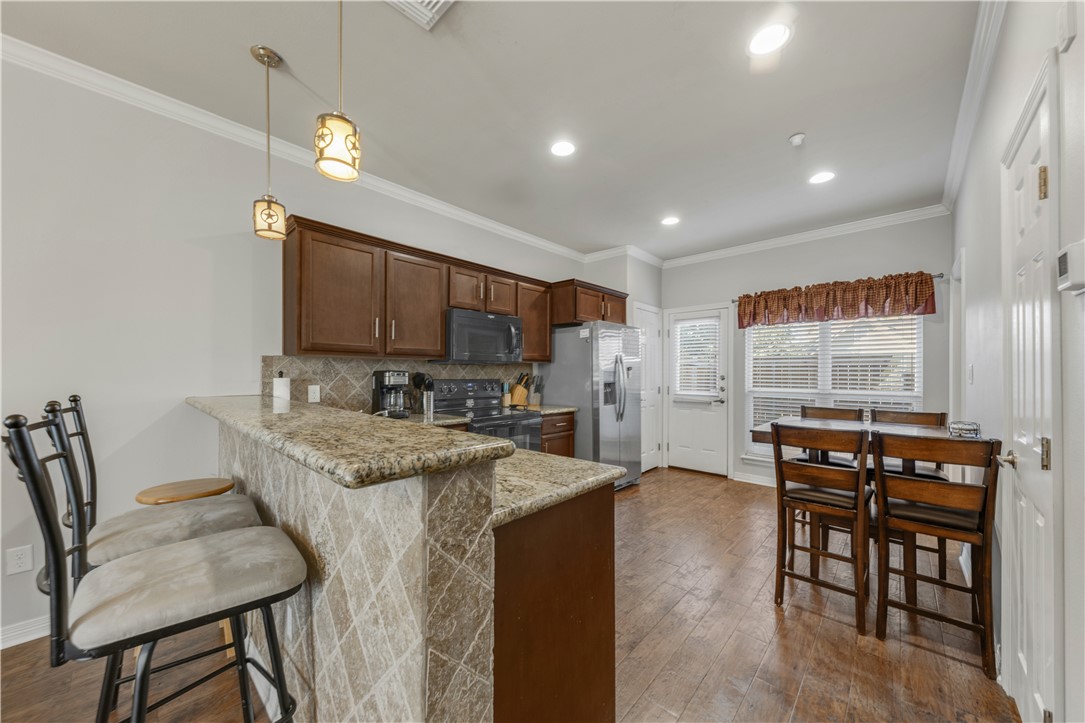 Kitchen featuring kitchen peninsula, light stone c