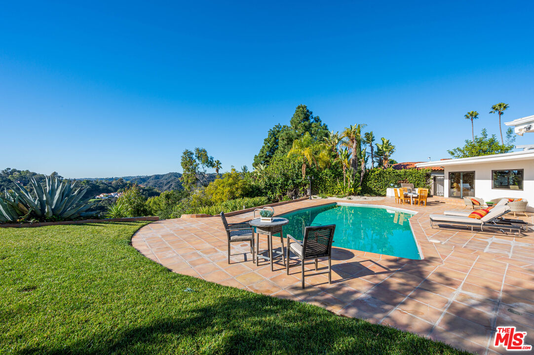 a view of a backyard with couches chair and potted plants