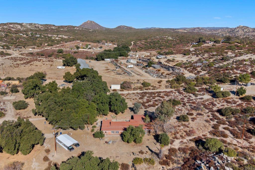 an aerial view of residential houses with outdoor space and trees