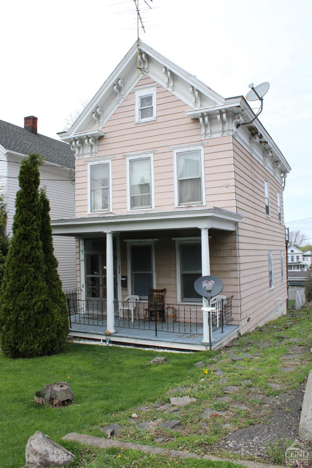 a front view of a house with a garden and patio