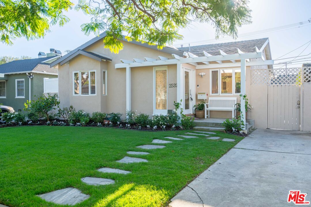 a front view of a house with a garden and plants