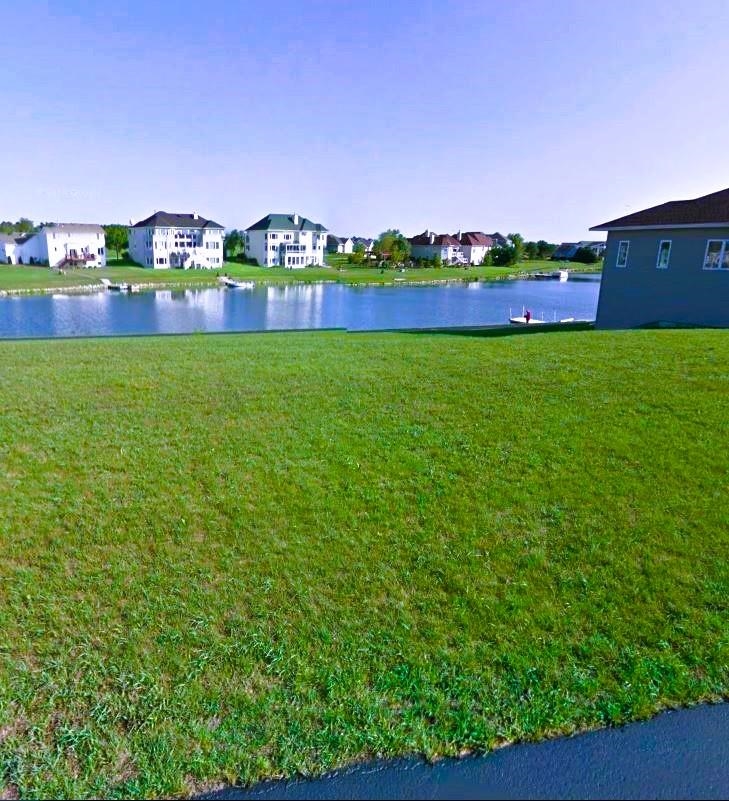 a view of yard with swimming pool and green space